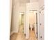 Hallway view to a white-walled bathroom with toilet and to closet with wire shelving at 6921 Foxmoor Way, Douglasville, GA 30134