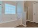 Bathroom features a tub with white tile surround and glass enclosed shower at 104 Sunflower Meadows Dr, Mcdonough, GA 30252