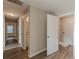 Hallway leading to a bathroom and laundry area with wood-look flooring throughout at 104 Sunflower Meadows Dr, Mcdonough, GA 30252