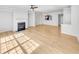 Open-concept room with hardwood floors, fireplace, and abundant natural light at 1869 Appaloosa Mill Ct, Buford, GA 30519