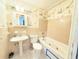 Bathroom featuring a pedestal sink, tub, and patterned wallpaper at 3276 Pin Oak Cir, Doraville, GA 30340