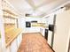 Retro kitchen with white cabinets, brick floors, and a full appliance package at 3276 Pin Oak Cir, Doraville, GA 30340