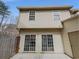 Back exterior of the house with beige siding, sliding glass doors, and a small patio at 3677 Utoy Sw Dr, Atlanta, GA 30331