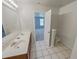 Bright bathroom featuring a double sink vanity, tiled floor and view into the adjacent bedroom at 3677 Utoy Sw Dr, Atlanta, GA 30331