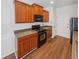 Kitchen with black appliances, wood cabinets and pantry at 3677 Utoy Sw Dr, Atlanta, GA 30331
