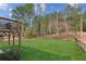 View of level backyard surrounded by chain link fence and wooded area at 972 Oakley Ln, Sugar Hill, GA 30518