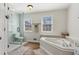 Bathroom features a glass shower, a soaking tub with jets, and wood-style floors at 972 Oakley Ln, Sugar Hill, GA 30518