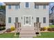 A charming two-story home with gray siding, a cozy front porch, and a well-kept lawn at 972 Oakley Ln, Sugar Hill, GA 30518