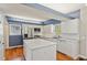 Bright kitchen with white cabinets, stainless steel appliances, an island and hardwood flooring at 972 Oakley Ln, Sugar Hill, GA 30518