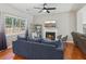 Living room featuring a fireplace, large window, modern furnishings, hardwood flooring, and neutral color scheme at 972 Oakley Ln, Sugar Hill, GA 30518