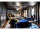 Modern primary bedroom with a grey panel wall, platform bed, custom art, and a blue velvet bench at 1388 Willow Sw Trl, Atlanta, GA 30311
