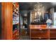 Spacious walk-in closet featuring custom wood shelves for shoes, clothes racks, drawers, and a statement light fixture at 1388 Willow Sw Trl, Atlanta, GA 30311