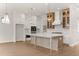 Modern kitchen featuring white cabinets, a large island, stainless steel appliances and wood flooring at 5424 Gallagher Ct, Powder Springs, GA 30127