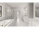 Bright main bathroom with double vanity, soaking tub, and a luxurious glass-enclosed shower with marble accents at 5424 Gallagher Ct, Powder Springs, GA 30127