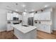 Bright kitchen with white cabinets, stainless steel appliances, center island, modern pendant lights, and hardwood floors at 5915 Pinnacle View Rd, Cumming, GA 30040