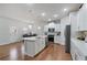 Modern kitchen features white cabinets, stainless steel appliances, an island with a sink, and hardwood floors at 5915 Pinnacle View Rd, Cumming, GA 30040