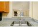 Kitchen with granite countertops, stainless sink, looking out to a living area with fireplace and tv at 970 Sidney Marcus Ne Blvd # 1208, Atlanta, GA 30324