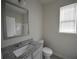 Well-lit bathroom boasts granite countertop, modern fixtures, and a large mirror at 2551 Bear Mountain St, Lithonia, GA 30058