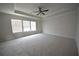 Carpeted bedroom features ceiling fan and large windows offering natural light at 2551 Bear Mountain St, Lithonia, GA 30058