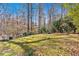 Large backyard featuring a lush lawn, mature trees, and a fire pit for outdoor relaxation and entertaining at 3699 Fowler Rdg, Douglasville, GA 30135