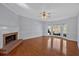 Bright living room with hardwood floors, a brick fireplace, ceiling fan, and large windows at 3699 Fowler Rdg, Douglasville, GA 30135