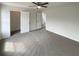 Spacious bedroom featuring neutral walls, carpet, ceiling fan with light, and two open doors leading to hallway and closet at 890 Abbotts Mill Ct # 75, Duluth, GA 30097