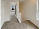 Hallway with carpet and neutral walls, open doors with a view of a bedroom and window with natural light at 890 Abbotts Mill Ct # 75, Duluth, GA 30097