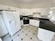 Bright white kitchen featuring modern appliances and sleek black countertops at 890 Abbotts Mill Ct # 75, Duluth, GA 30097