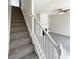 Carpeted stairs with a white railing lead to the upper level at 890 Abbotts Mill Ct # 75, Duluth, GA 30097