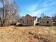 View of back yard with home, detached garage, and trees at 10067 Freeman Ct, Jonesboro, GA 30236