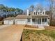 Charming home featuring a welcoming porch, dormer windows, attached garage, and a separate garage at 10067 Freeman Ct, Jonesboro, GA 30236