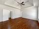 Primary bedroom featuring a tray ceiling, hardwood floors, and multiple closets at 10067 Freeman Ct, Jonesboro, GA 30236