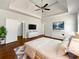 Staged main bedroom featuring a tray ceiling, hardwood floors, and a ceiling fan at 10067 Freeman Ct, Jonesboro, GA 30236