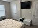 Bedroom featuring a white storage unit, wall-mounted TV, and a door at 3419 In Bloom Way, Auburn, GA 30011