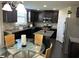 Modern kitchen featuring dark cabinetry, granite countertops, and stainless steel appliances with dining area at 3419 In Bloom Way, Auburn, GA 30011