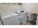 A practical laundry room is equipped with modern washer and dryer, alongside an ironing board at 3419 In Bloom Way, Auburn, GA 30011