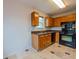 A functional kitchen with wood cabinets, black appliances and tiled flooring at 4096 Mistymorn Ln, Powder Springs, GA 30127