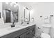 Bright bathroom featuring a gray double vanity, black hardware, marble floors, modern lighting, and a toilet at 3367 Spring Meadow Ct, Tucker, GA 30084