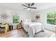 Bright bedroom featuring hardwood floors, a ceiling fan, and plenty of natural light from the windows at 3367 Spring Meadow Ct, Tucker, GA 30084