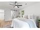 This cozy bedroom features a modern ceiling fan, bright white walls, and a trendy sliding barn door to the bathroom at 3367 Spring Meadow Ct, Tucker, GA 30084