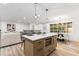 Bright kitchen with a large island featuring a microwave and a dining area with modern pendant lighting at 3367 Spring Meadow Ct, Tucker, GA 30084