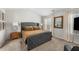 This primary bedroom features a grey tufted headboard, neutral walls, carpeted floor and bright natural light at 461 Charleston Pl, Villa Rica, GA 30180