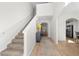 Inviting foyer with staircase, wood flooring, arched entryway, and view to the kitchen and living area at 461 Charleston Pl, Villa Rica, GA 30180