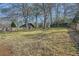 Large grassy backyard with mature trees and a wooden fence, offering privacy at 4722 Bexley Dr, Stone Mountain, GA 30083