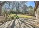 Spacious backyard with mature trees, large paved area, and wooden fence at 4722 Bexley Dr, Stone Mountain, GA 30083