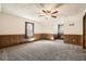 Spacious bedroom featuring wainscoting, neutral carpet, ceiling fan, and natural light at 4722 Bexley Dr, Stone Mountain, GA 30083