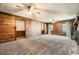 Expansive carpeted living room with wood-paneled walls, a ceiling fan, and windows, offering ample natural light at 4722 Bexley Dr, Stone Mountain, GA 30083