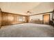 Bright living room featuring cozy carpeting, wood-paneled walls, and a window for natural light at 4722 Bexley Dr, Stone Mountain, GA 30083