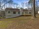 View of the rear exterior featuring a spacious wooden deck and a partially wooded lot at 521 Country Lake Dr, Mcdonough, GA 30252