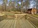 View of backyard with a large deck and barn-style shed nestled among the trees at 521 Country Lake Dr, Mcdonough, GA 30252